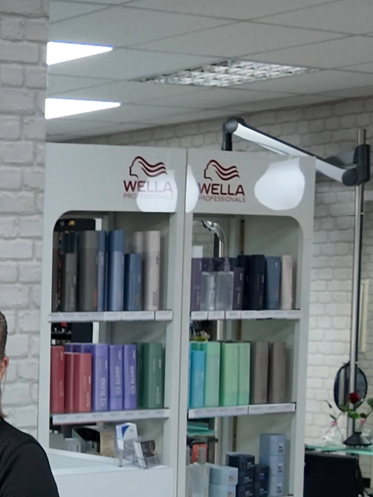 Produktregal im Salon mit Wella-Pflege und Farbsortiment