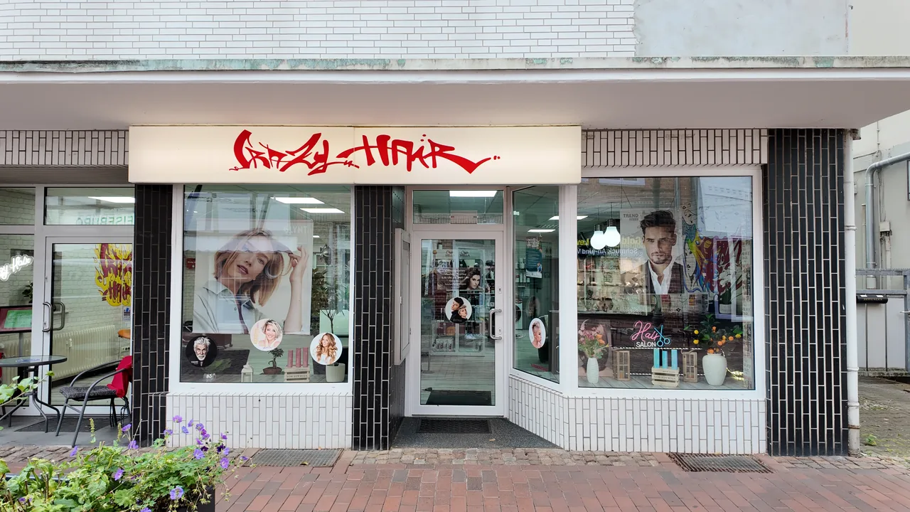 Ladenzeile an der Lüneburger Straße mit dem roten Crazy-Hair-Schriftzug über dem Schaufenster